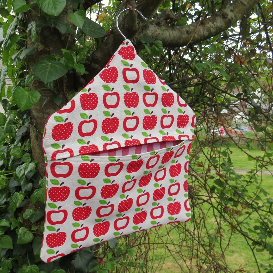 A peg bag with a red apples design.