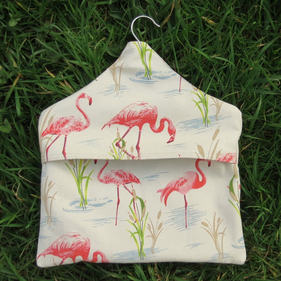 A peg bag with a pink flamingos design.  Laundry.  Peg storage.