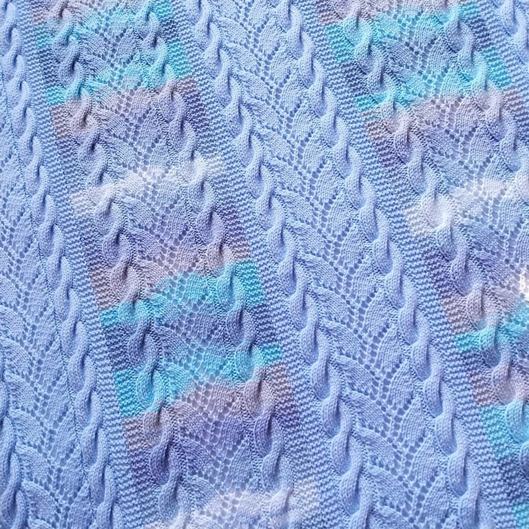 Baby blanket hand knitted in blue mixture stripes and cables