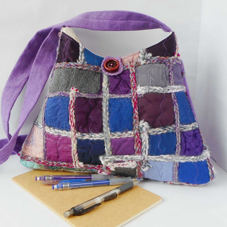 Pyramid shaped cross body shoulder bag in purple jewel tones