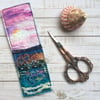 Embroidered up-cycled sunset seascape bookmark.