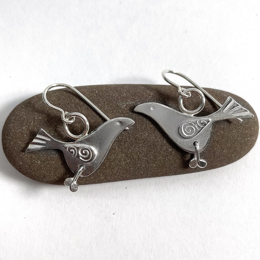 Silver bird earrings with swirly wings and jiggly legs