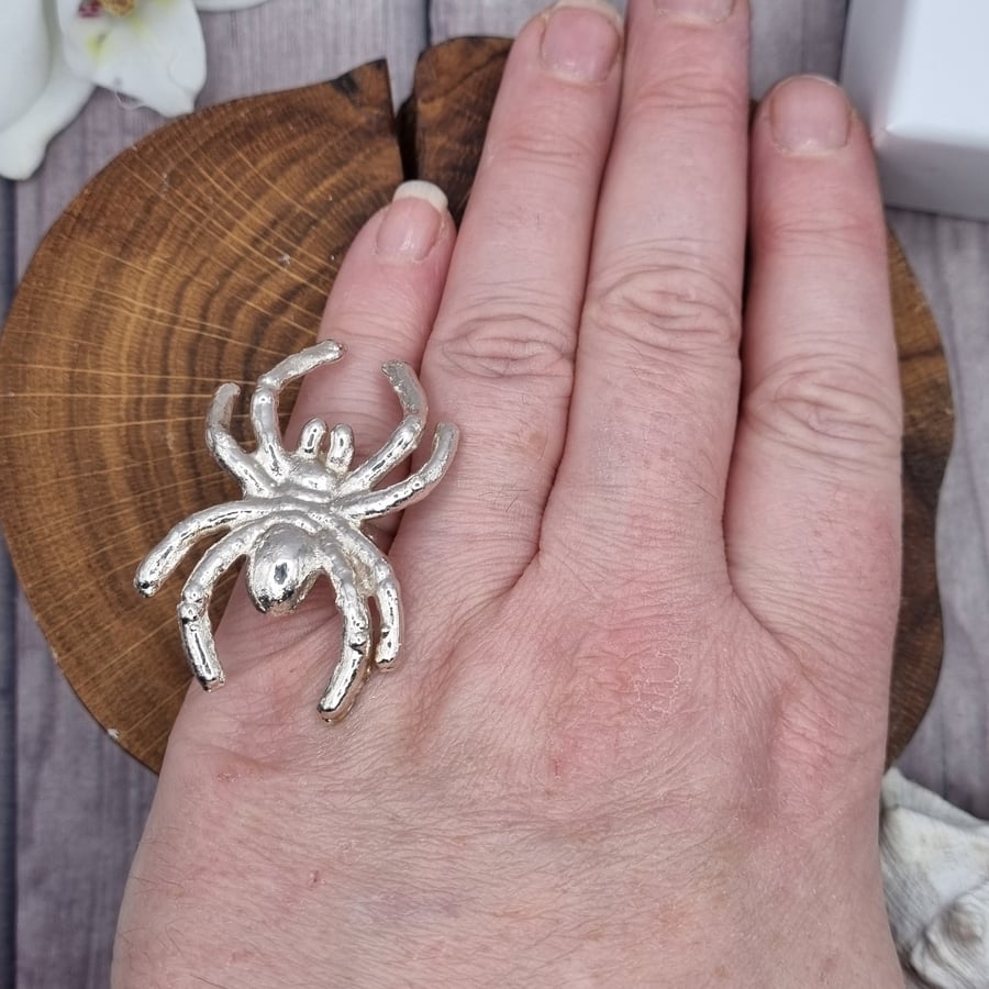 Large plastic spider covered in silver on ring, size L