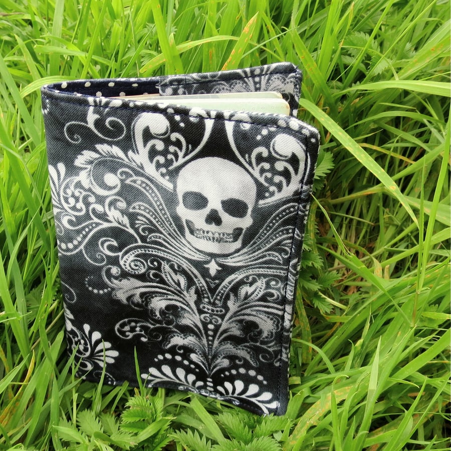 A passport sleeve with a skulls design.  Passport cover.