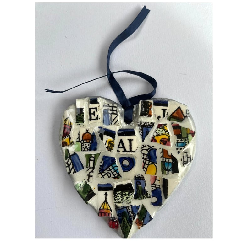 A heart shaped mosaic pendant with letters E, J, A and L, in blues and pinks.