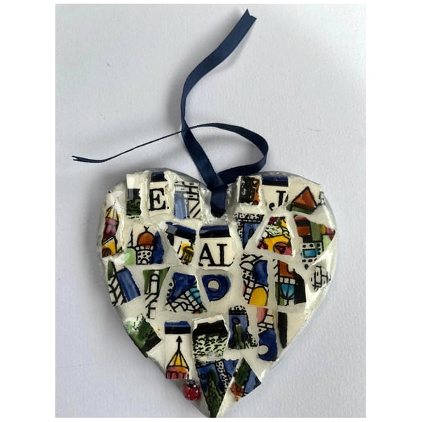 A heart shaped mosaic pendant with letters E, J, A and L, in blues and pinks.