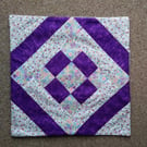 Purple patchwork cushion cover. Mauve floral and deep purple. 37cm sq.