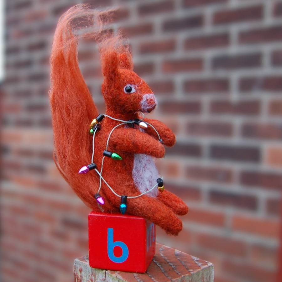 Squirrel holding a string of Christmas Fairy Lights   - needlefelt.   