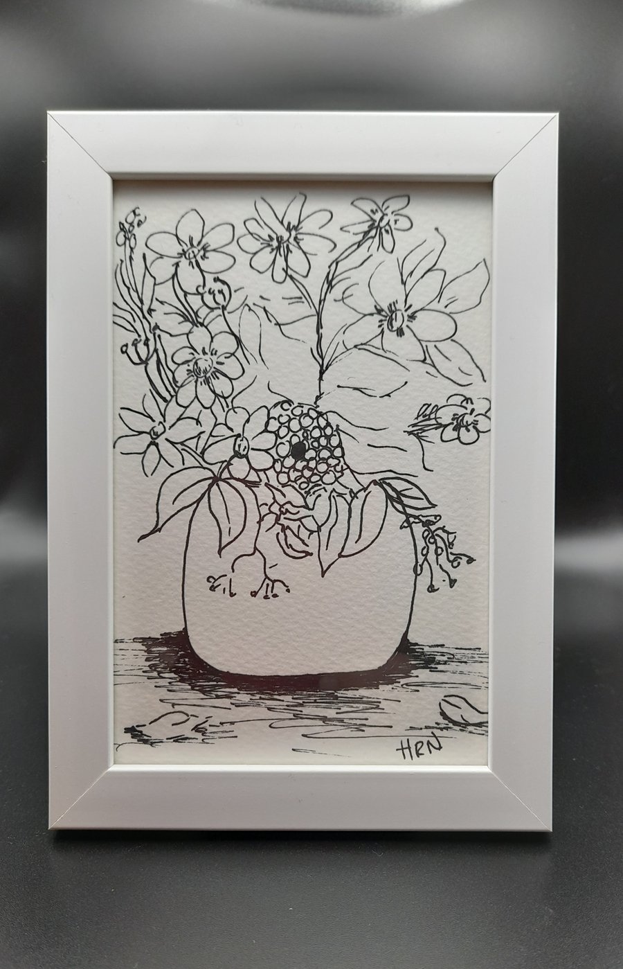 fine point pen drawing of flowers in a pot in a white frame ready to hang