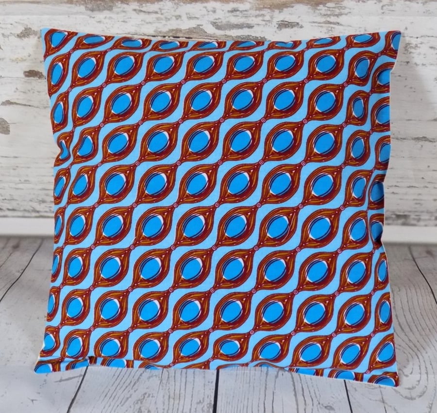 Cushion cover. African wax print, blue circles in brown ovals