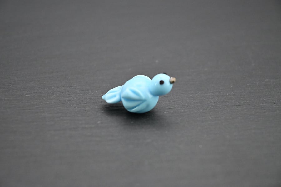 small glass blue bird