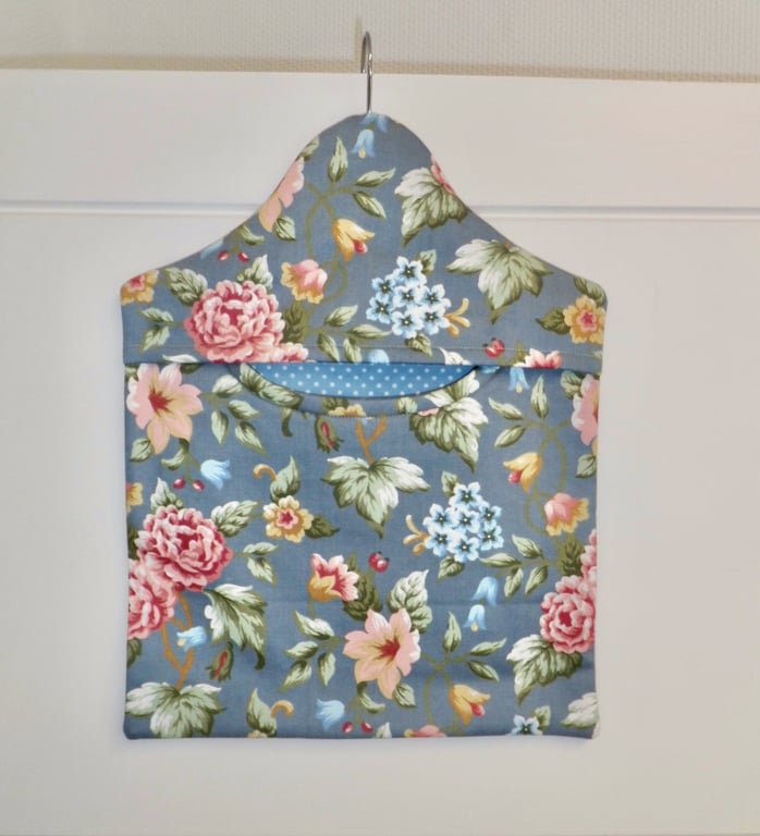 Peg bag in blue floral print with a spotted lining.