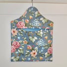 Peg bag in blue floral print with a spotted lining.