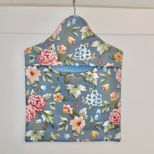 Peg bag in blue floral print with a spotted lining.