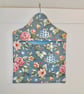 Peg bag in blue floral print with a spotted lining.