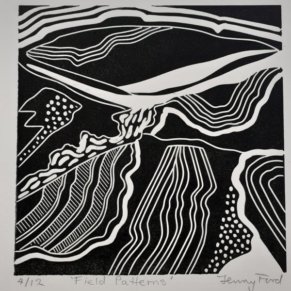 Black and white linocut of field patterns.