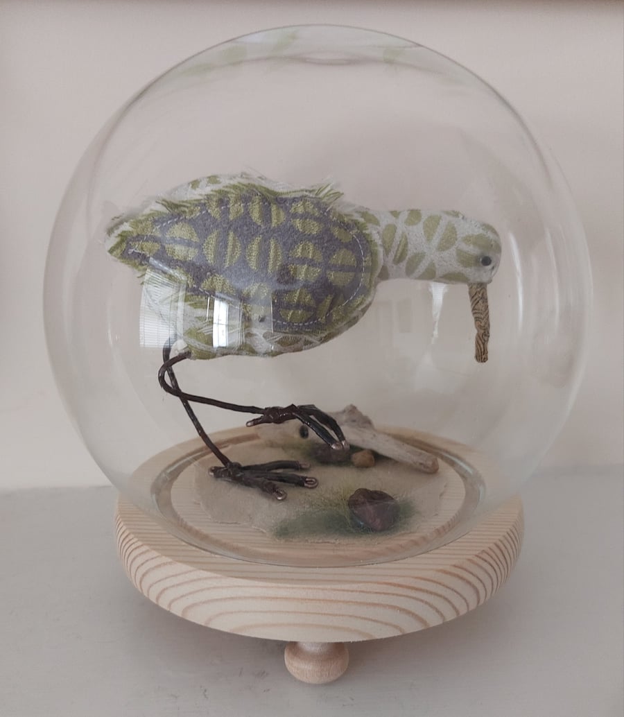 Wading bird soft sculpture in glass case.