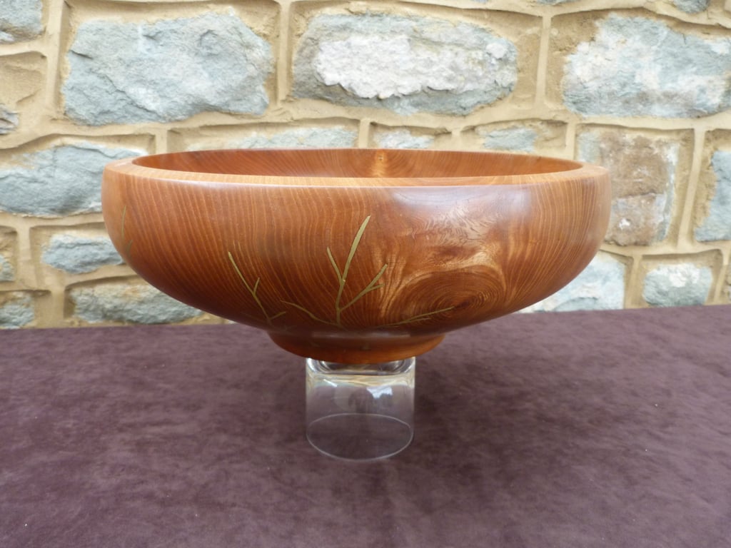 AN ELM BOWL WITH  BRASS DECORATED OUTER FACE