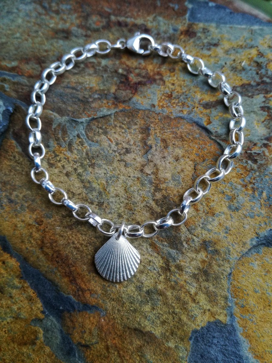 Silver bracelet with shell charm.