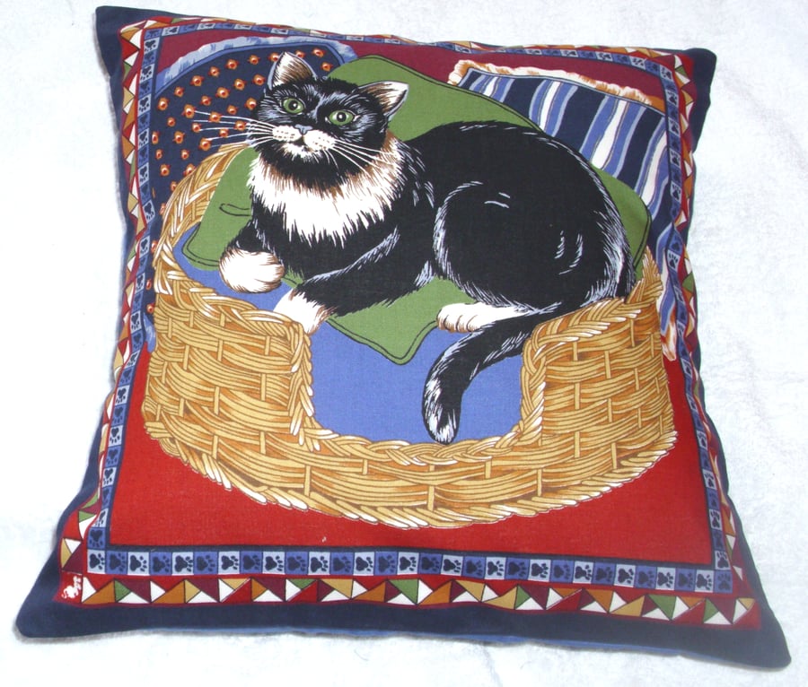 Lovely black and white cat sitting in a basket cushion