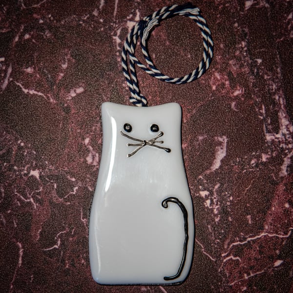 A fused glass cat light-catcher in white.