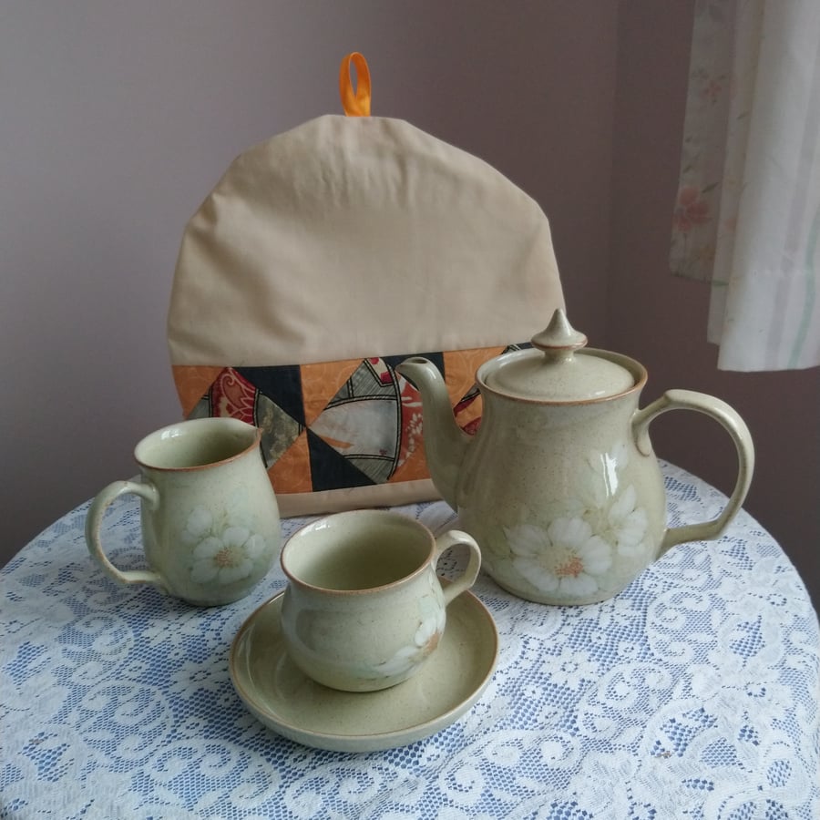 Tea cosy in peach, beige, orange and grey. Handsewn patchwork