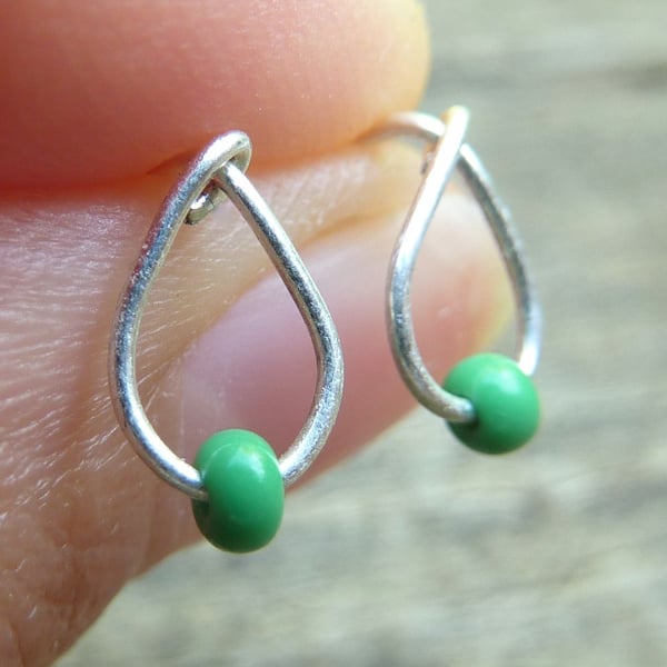 Silver drop shape stud earrings with tiny green seed bead 
