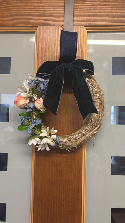 Hand decorated mini straw wreath with navy velvet bow and floral accents