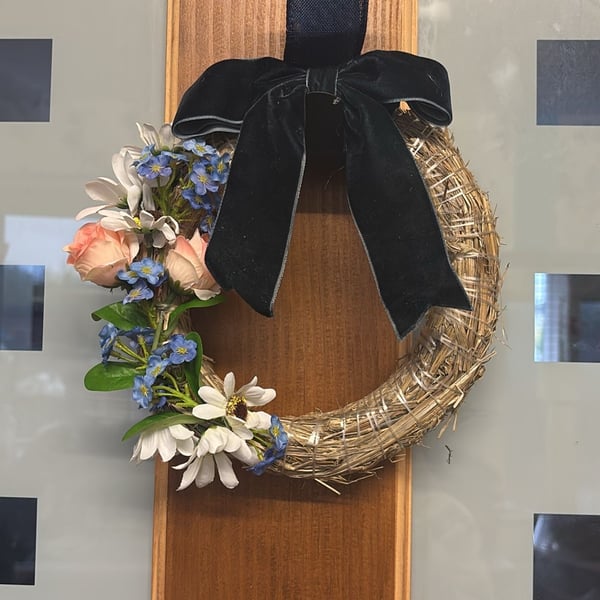 Hand decorated mini straw wreath with navy velvet bow and floral accents