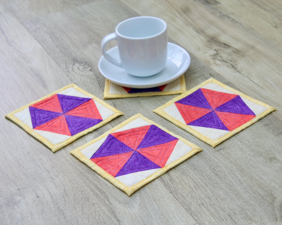Set of four quilted coasters with a traditional hexagon patchwork design.