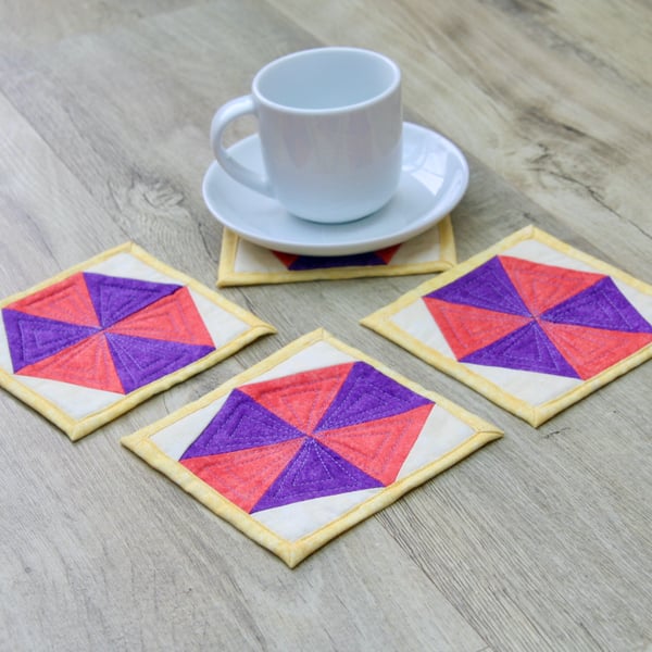 Set of four quilted coasters with a traditional hexagon patchwork design.
