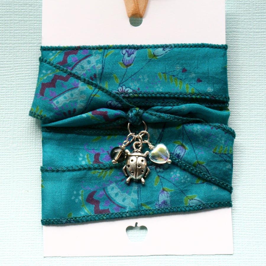 Teal silk wrap bracelet with ladybird charm