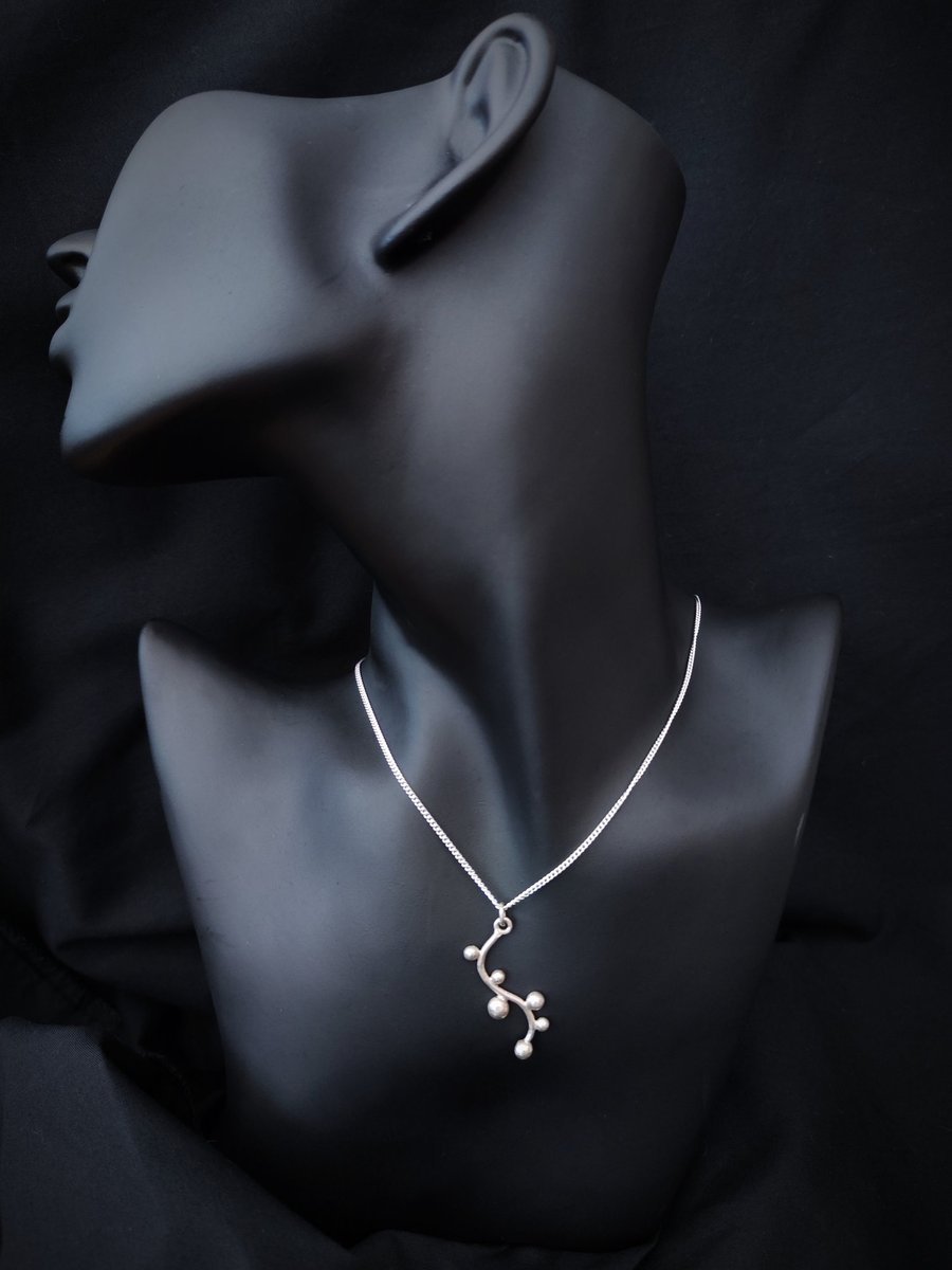 Wavy silver pendant with pebbles