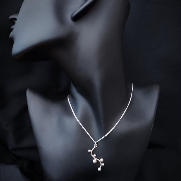 Wavy silver pendant with pebbles