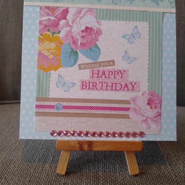 a happy birthday card with flowers and butterflys