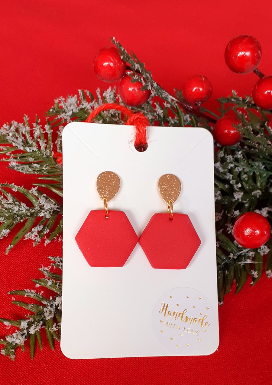 Red and gold coloured hexagonal drop earrings.