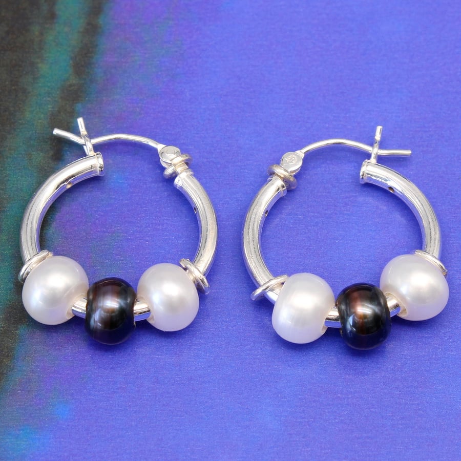 Handmade freshwater pearl earrings featuring white and peacock pearls. 