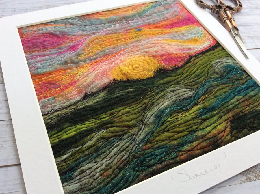 Embroidered wet felting landscape of the sun setting. 