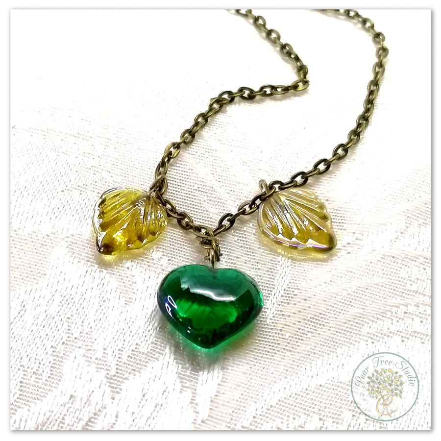 Handmade necklace with yellow glass leaf beads and a dark green heart