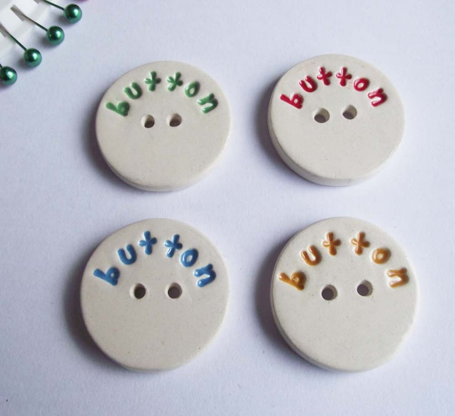 Set of four large ceramic buttons with the word button on the front