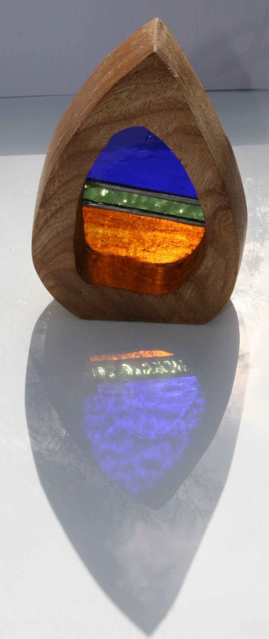 Handmade stained glass sun catcher in a solid wood feature surround.