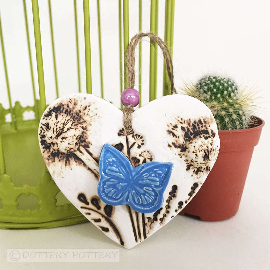 Pottery heart decoration with natural flower design and butterfly