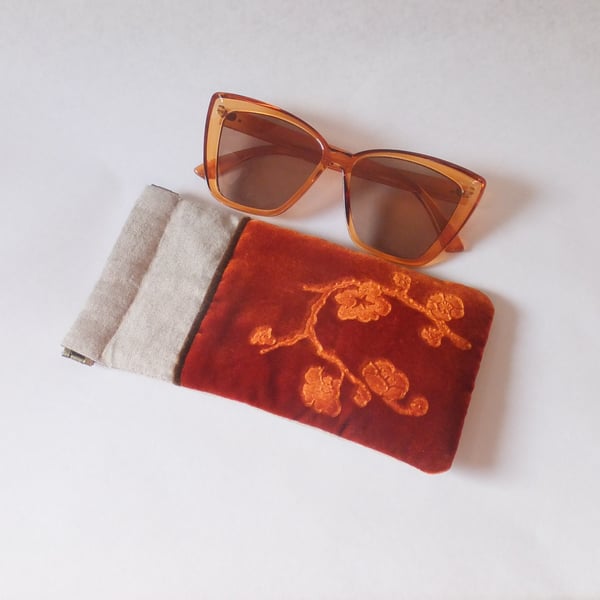 Glasses case featuring orange floral design embossed velvet & linen, snap top.