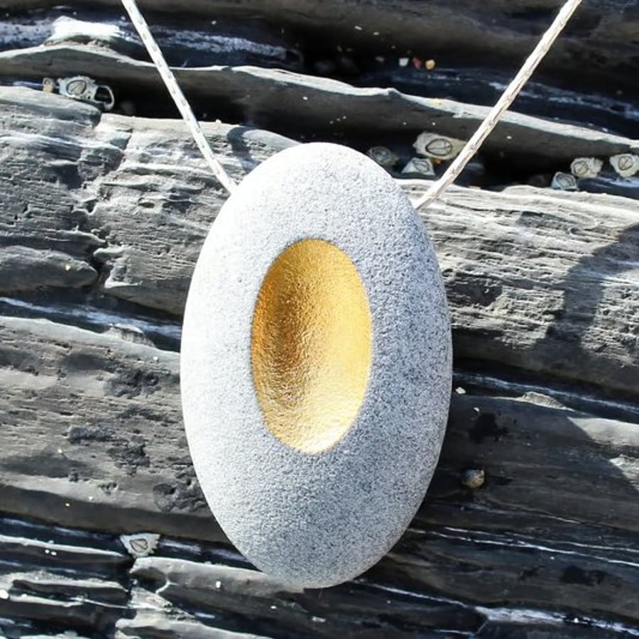 Pebble pendant necklace with a golden identation desgined by John Field jeweller