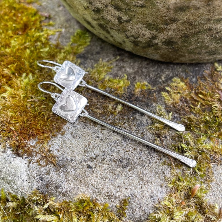 Silver long dangly pendulum earrings with hearts.