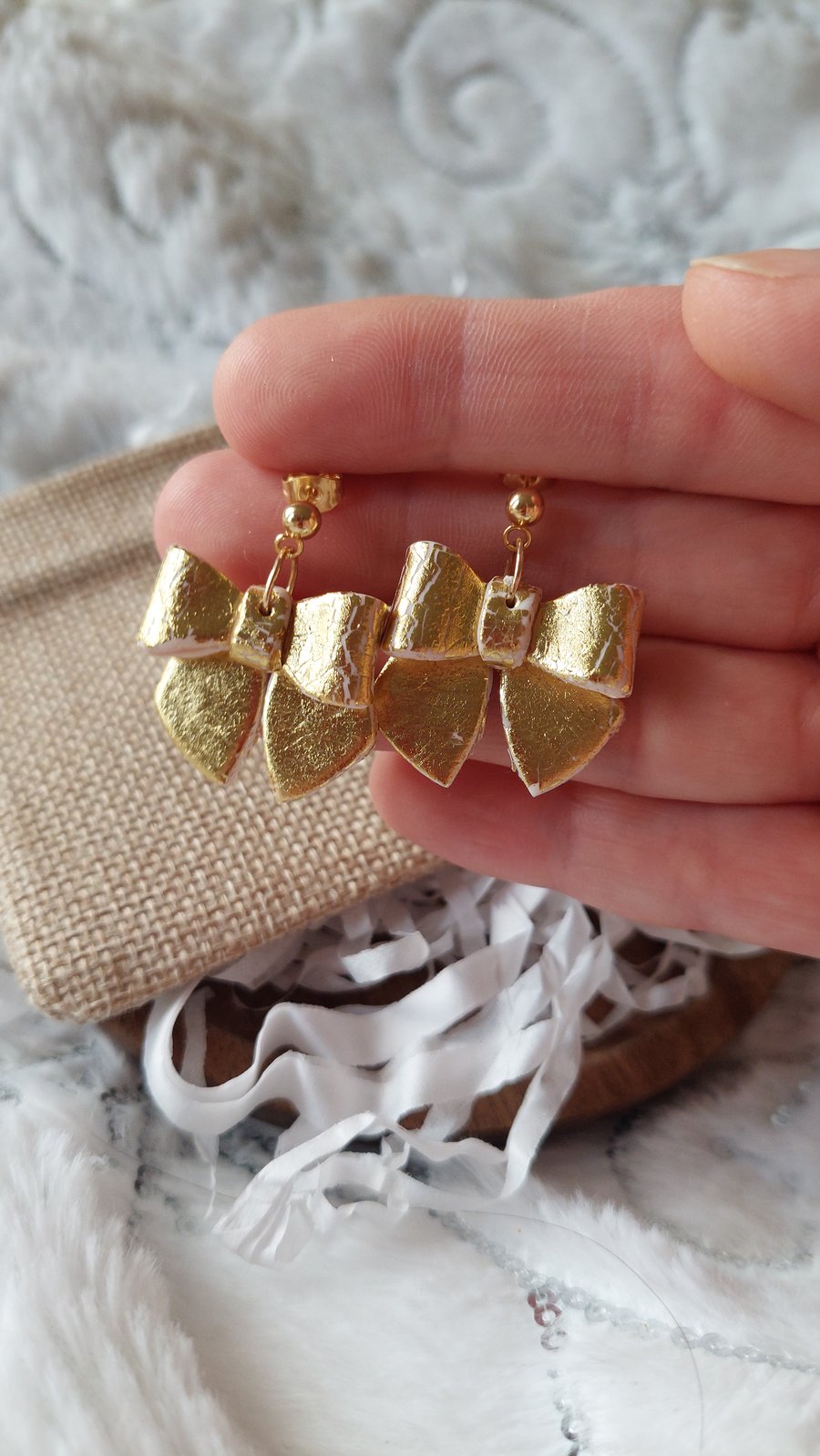 Gold bow dangle earrings.