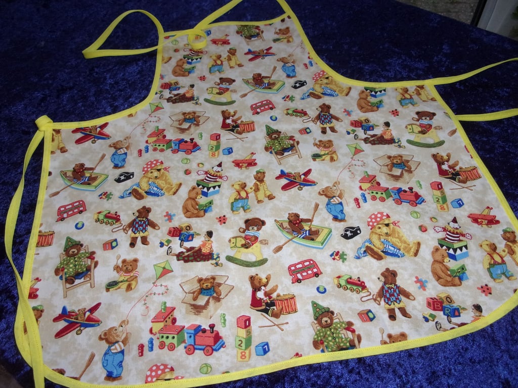 Teddy Bears, Trains and Kites on a Dark Cream Background Baby Apron
