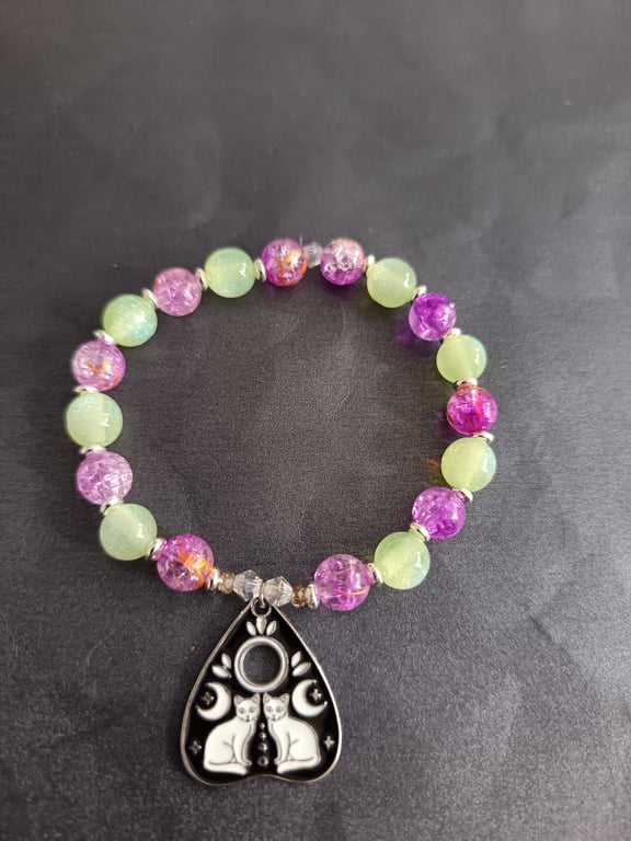 Elasticated green and purple bead bracelet with cat planchette charm