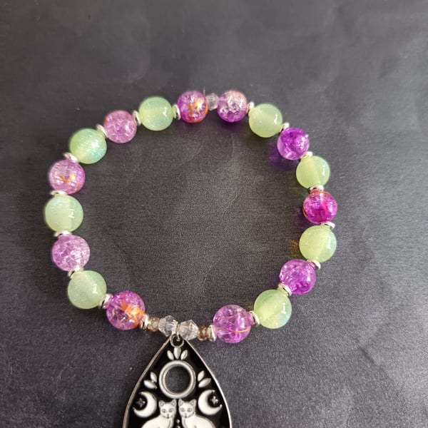Elasticated green and purple bead bracelet with cat planchette charm