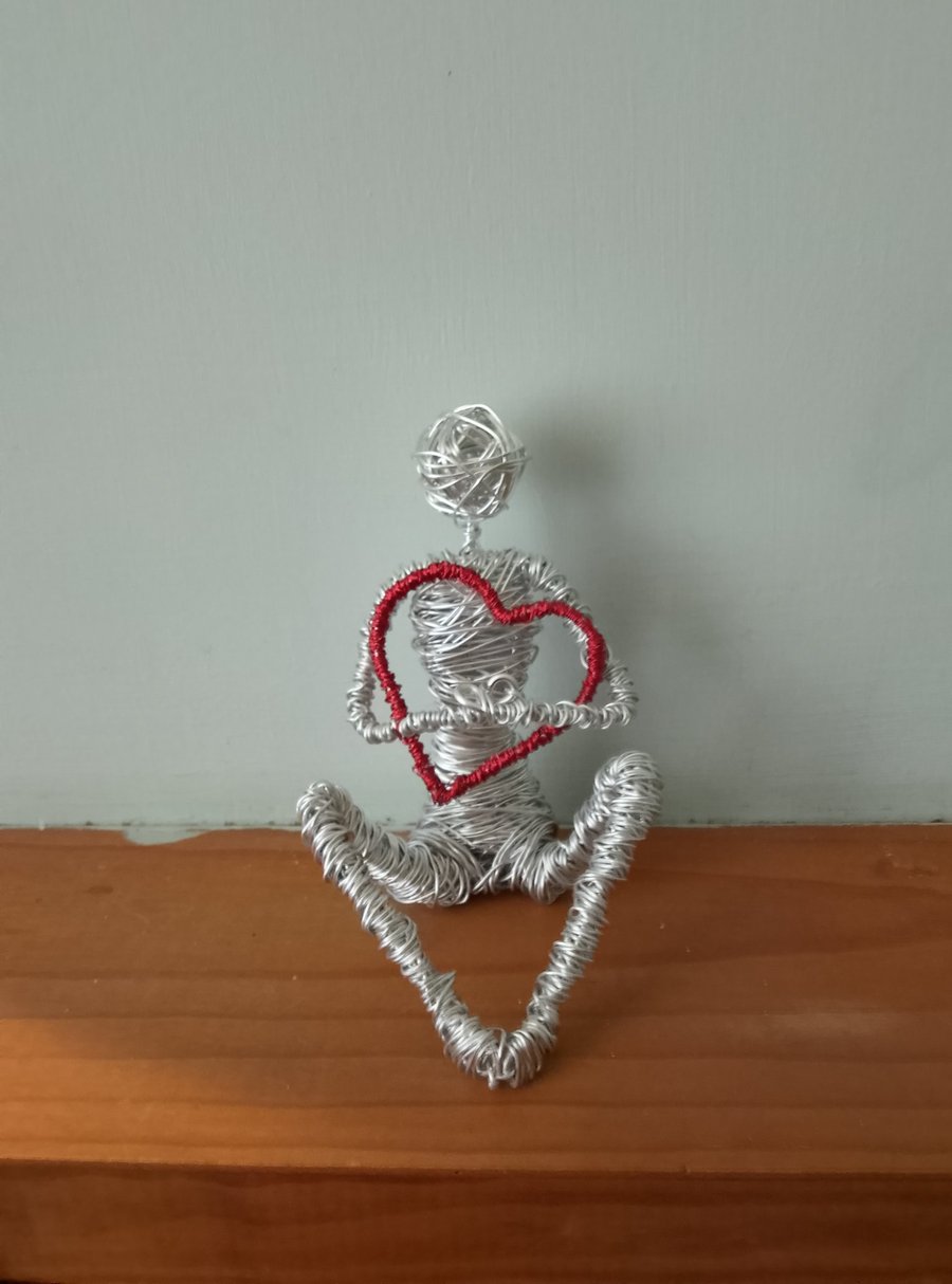 Figure Holding onto love wire art sculpture 
